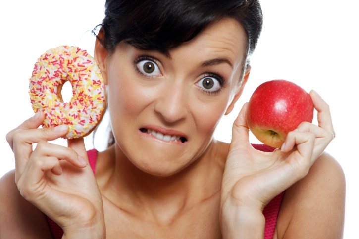 Emotional eating - woman choosing between donut and apple