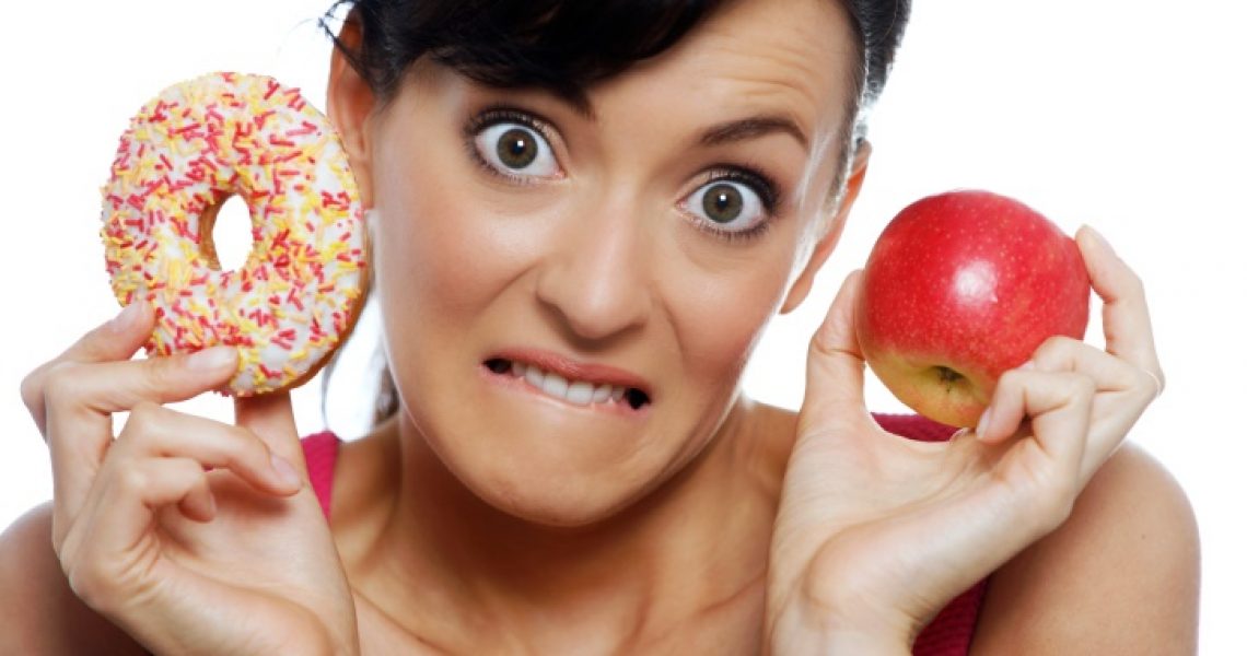 Emotional eating - woman choosing between donut and apple